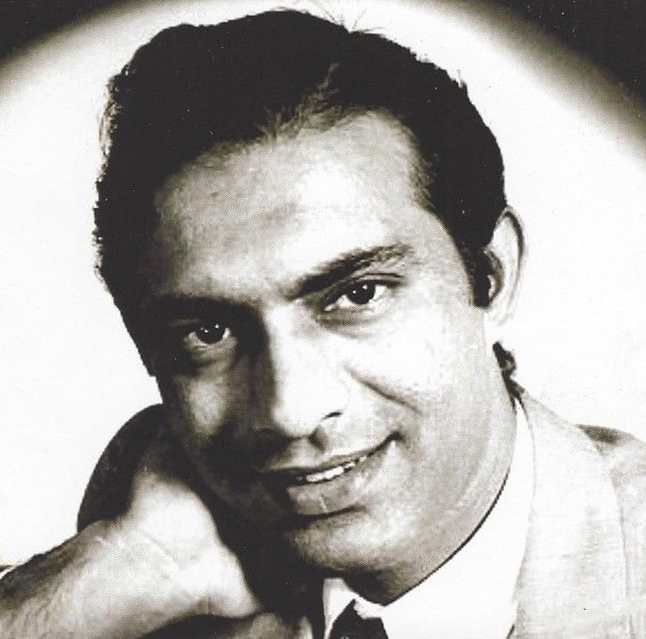 A black-and-white portrait of Talat Mahmood resting his chin on his hand