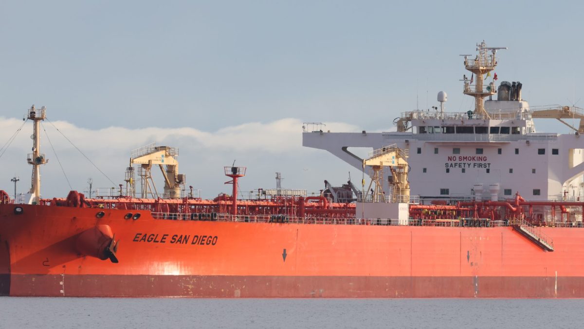 A red crude oil tanker moored in a harbour