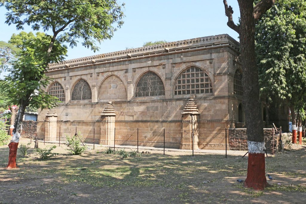 The arched stone facade of the Sidi Saiyyed Mosque in Ahmedabad with its carved lattice windows