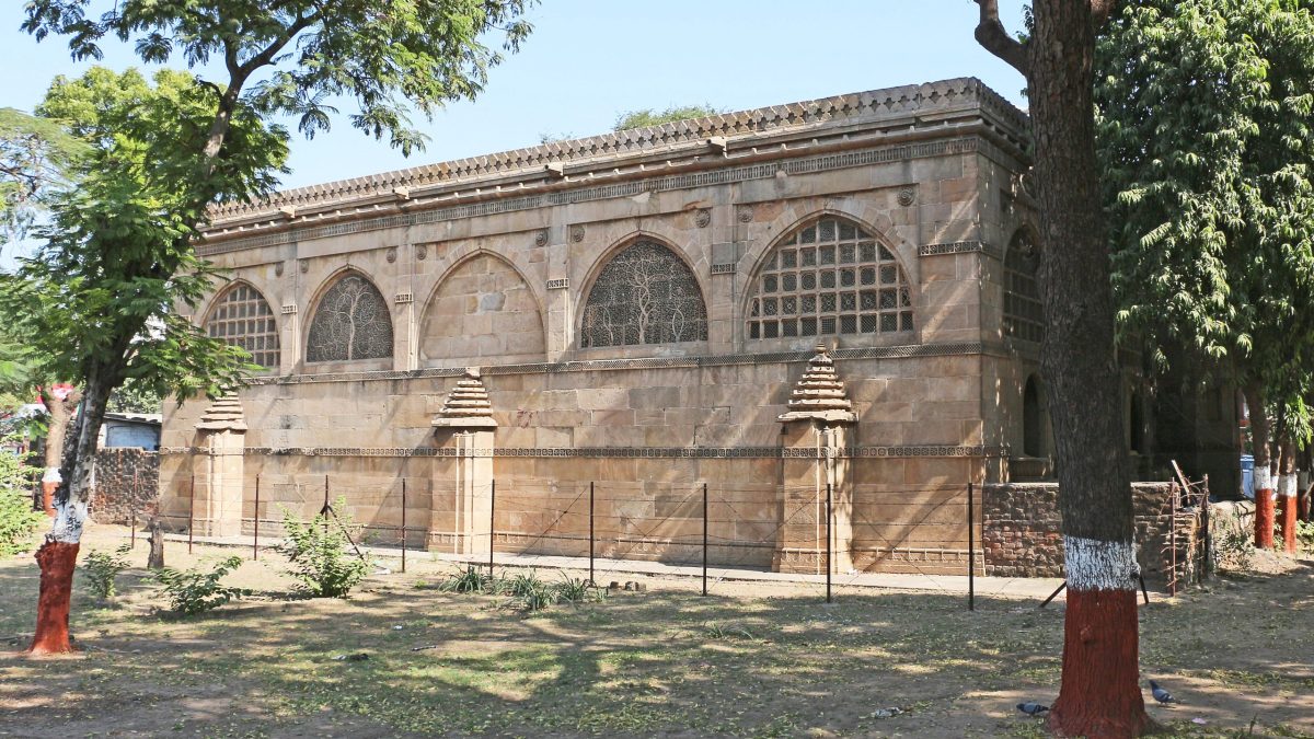 The arched stone facade of the Sidi Saiyyed Mosque in Ahmedabad with its carved lattice windows