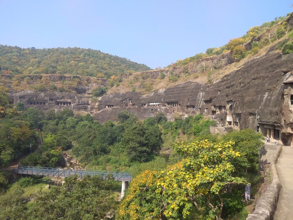 A view of the rock-cut Ajanta Caves in the cliff of the Waghora gorge
