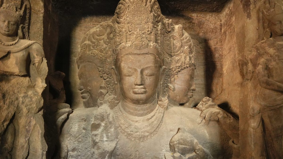 The colossal three-headed bust of Shiva carved in the rock inside the main cave at Elephanta