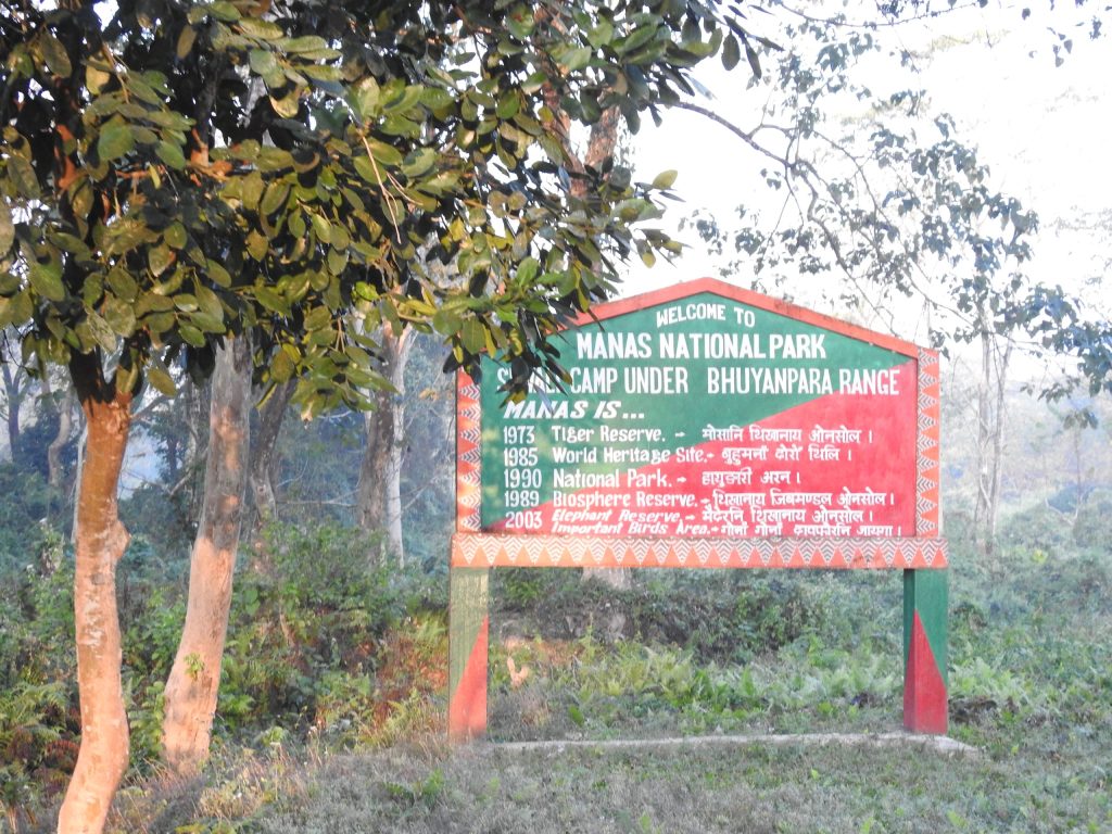 A signboard standing among trees at Manas National Park in Assam