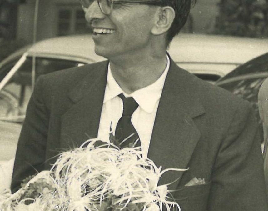 A black-and-white photograph of Umashankar Joshi in glasses and a suit, holding a garland