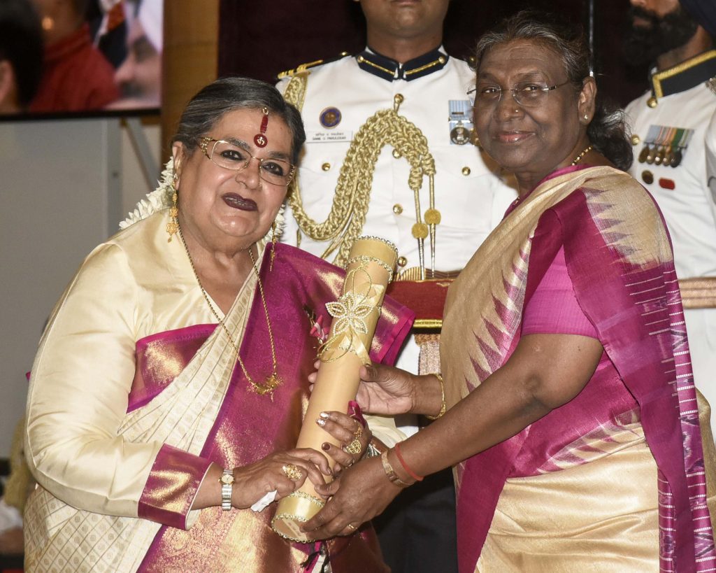 Usha Uthup in a cream and pink silk sari receiving the Padma Bhushan from President Droupadi Murmu
