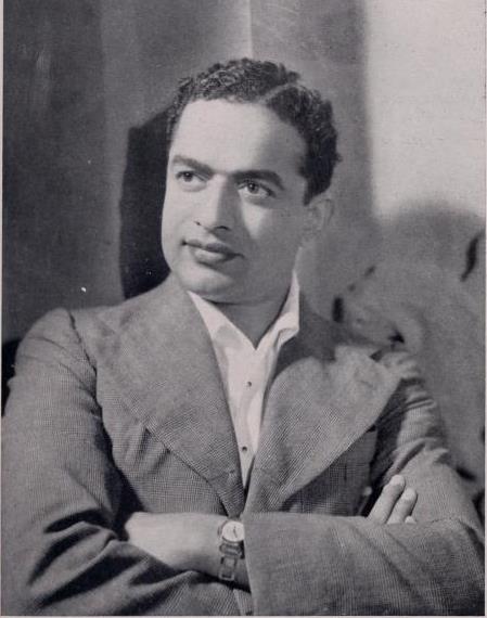 A black-and-white portrait of V. Shantaram in a suit