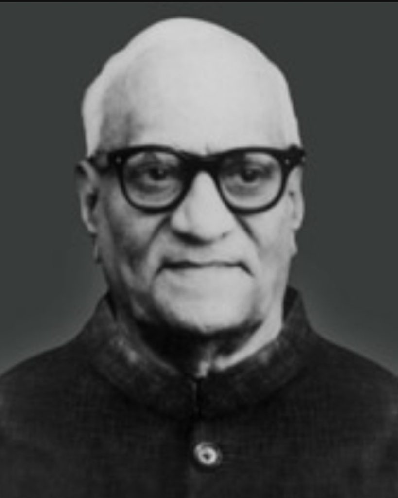 A black-and-white portrait of V. V. Giri in glasses and a dark coat