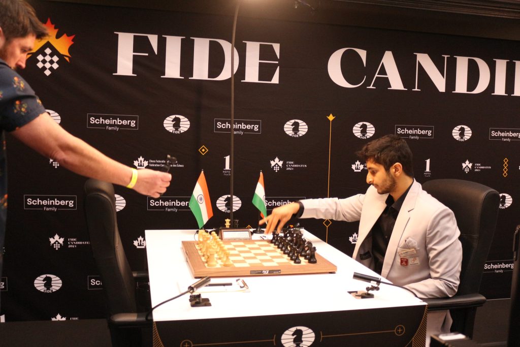 Vidit Gujrathi in a grey suit seated at a chessboard at the Candidates Tournament