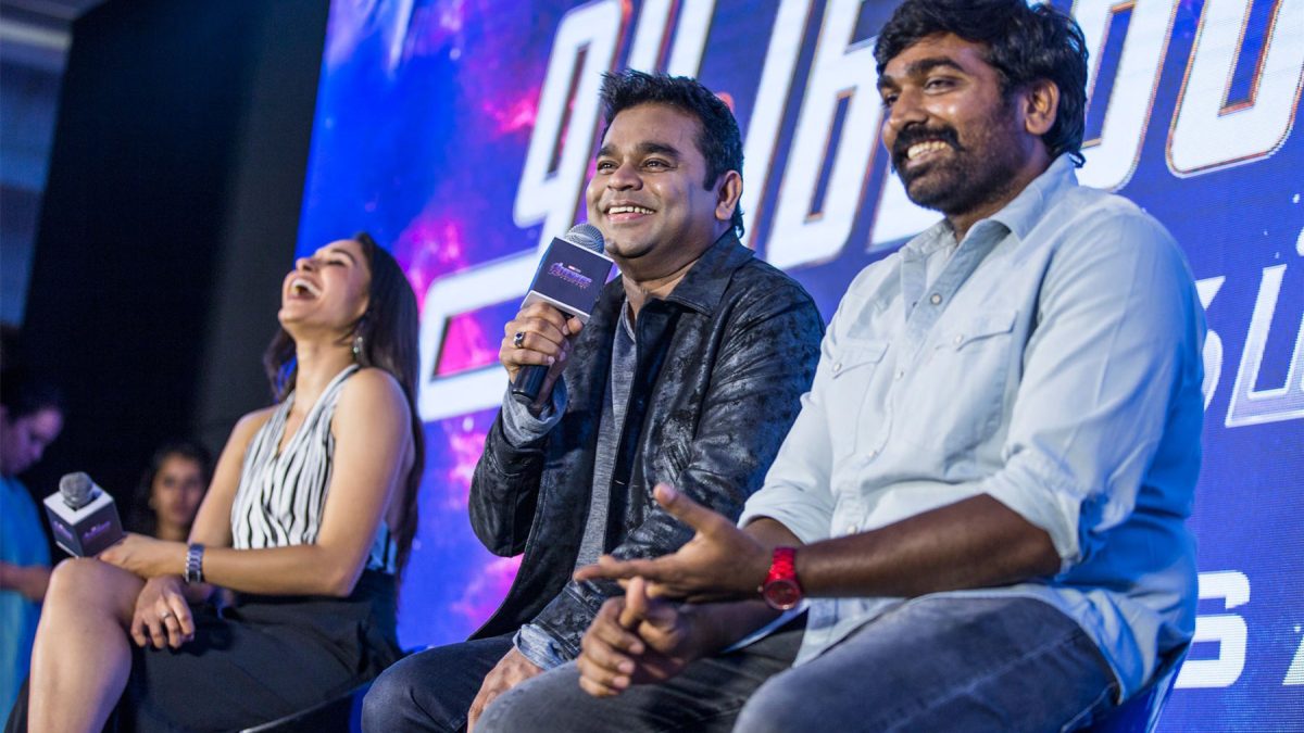 Vijay Sethupathi with a beard, in a blue shirt, smiling beside A. R. Rahman at a launch event