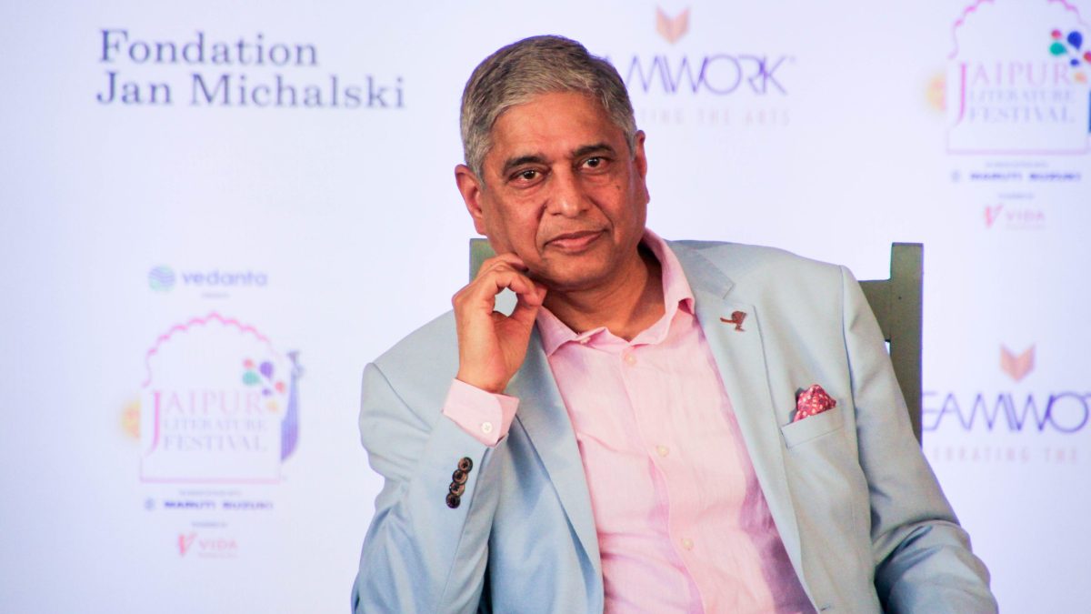 Vikas Swarup in glasses and a light blue jacket speaking into a microphone