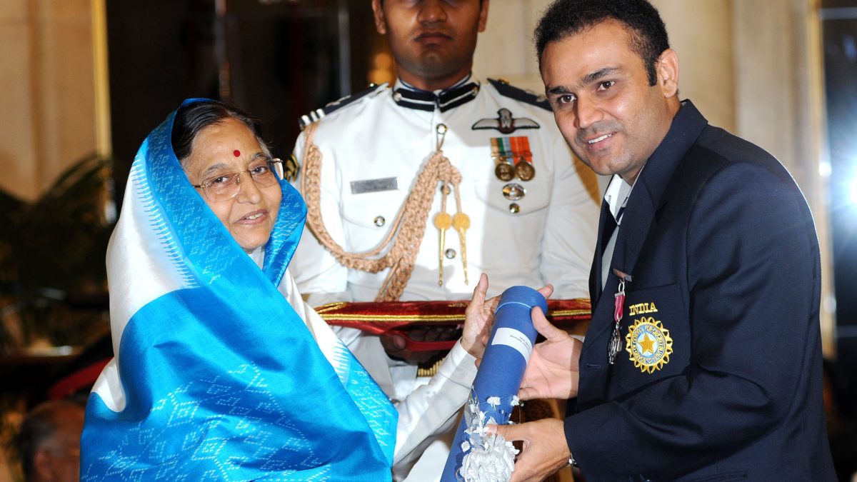 Virender Sehwag in a navy blazer receiving the Padma Shri from President Pratibha Patil