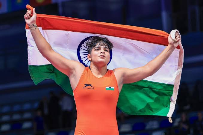 An Indian wrestler holds the tricolour flag aloft after a bout at the World Wrestling Championships