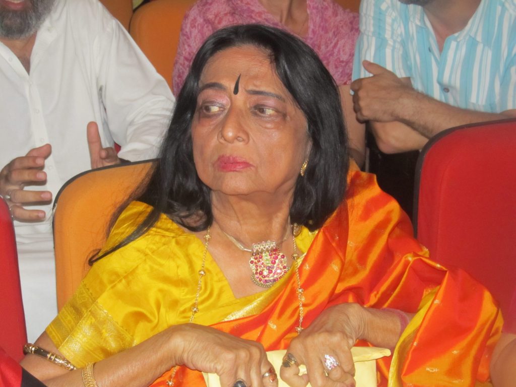 Yamini Krishnamurthy seated in an orange sari