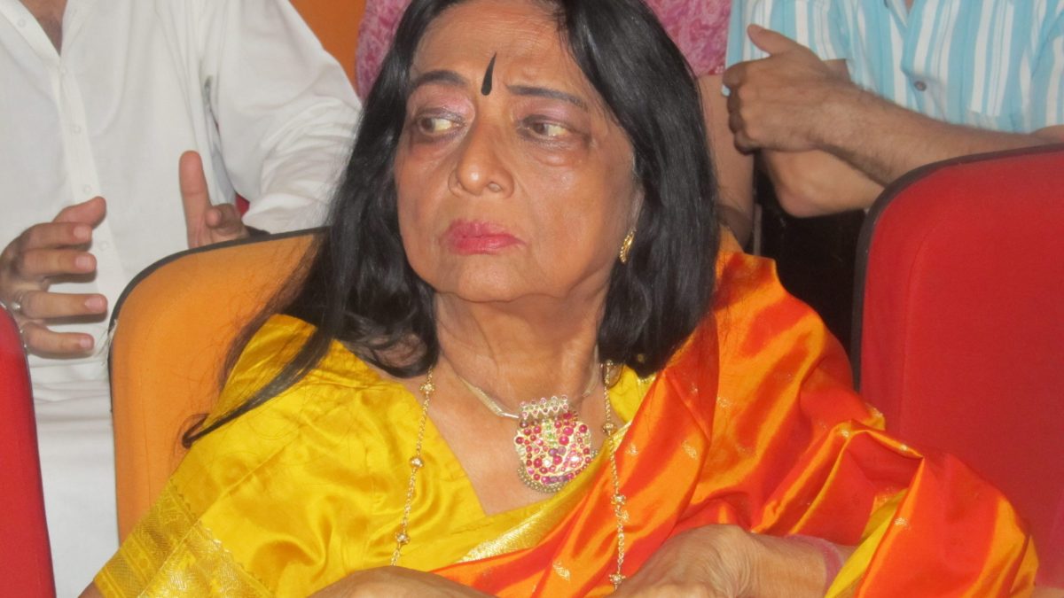 Yamini Krishnamurthy seated in an orange sari