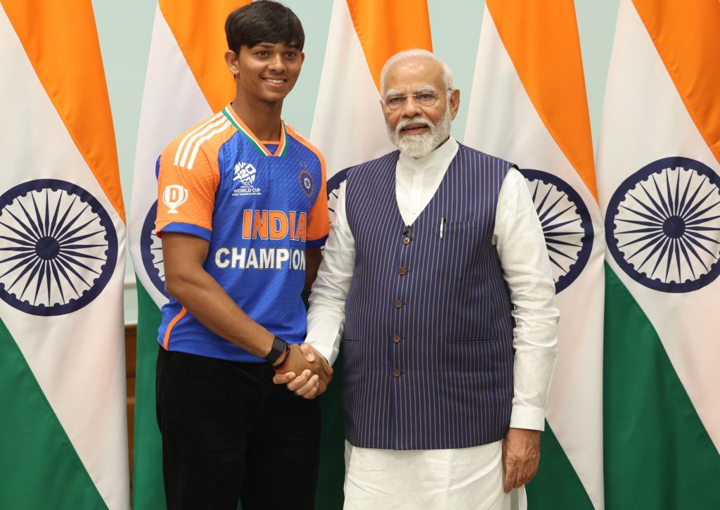 Yashasvi Jaiswal in India's champions jersey shaking hands with Prime Minister Narendra Modi