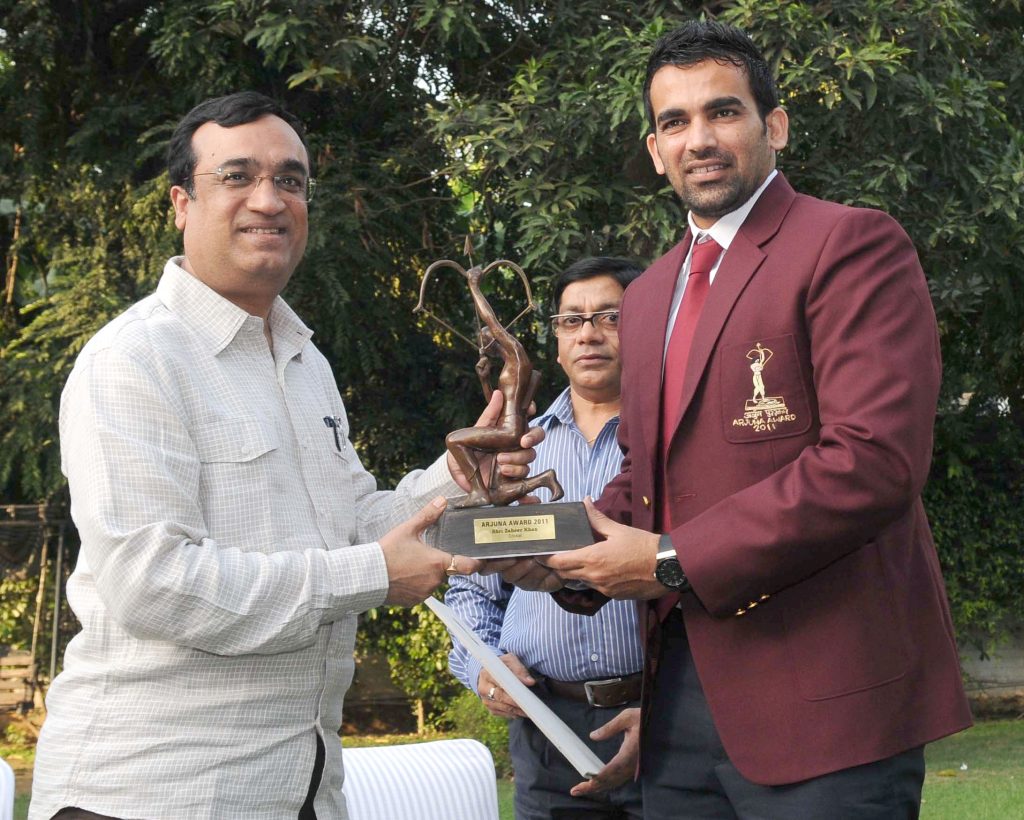 Zaheer Khan in a maroon blazer receiving the Arjuna Award trophy