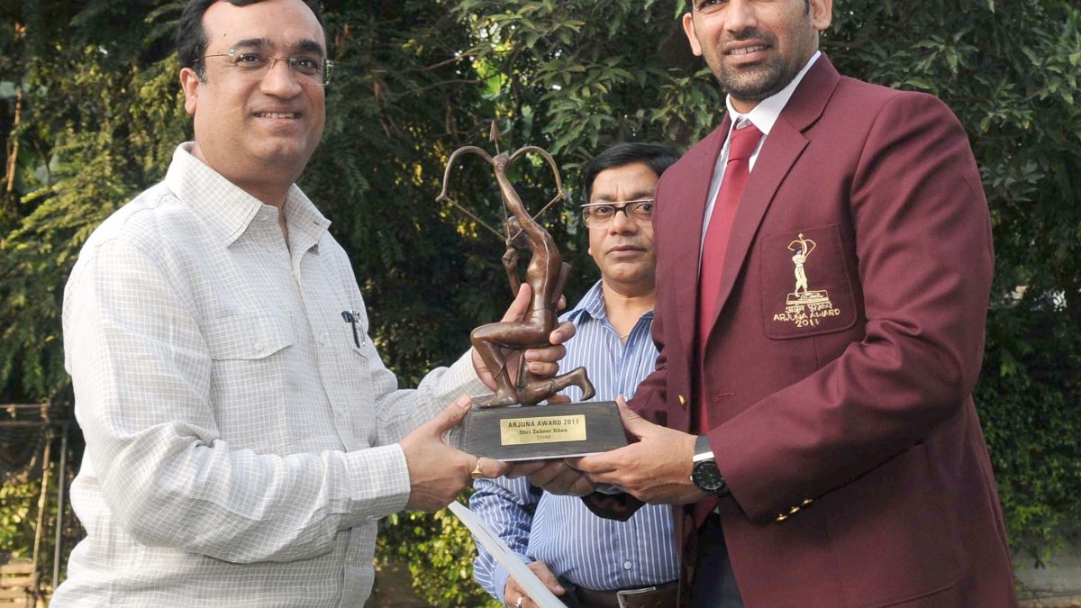 Zaheer Khan in a maroon blazer receiving the Arjuna Award trophy