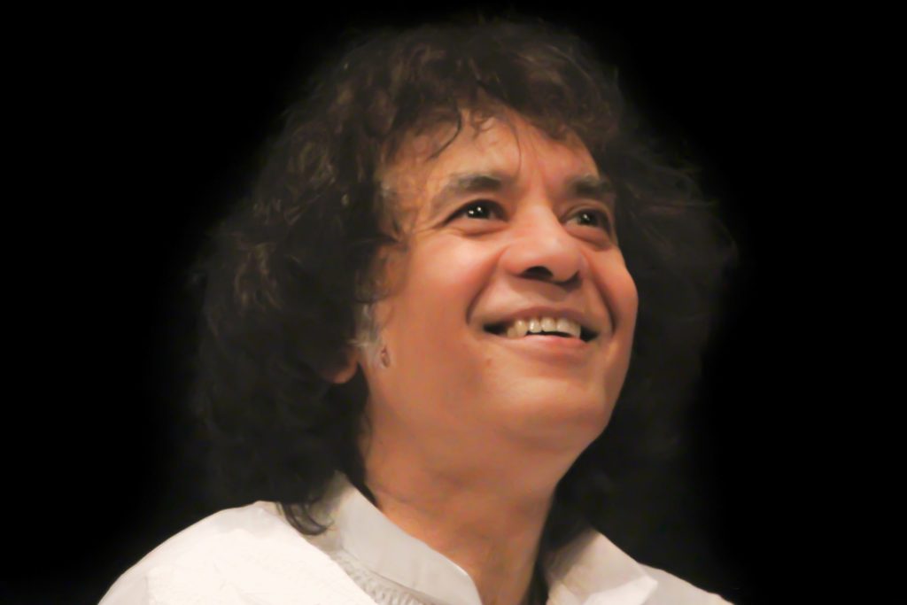 Close-up of Zakir Hussain smiling and looking upward