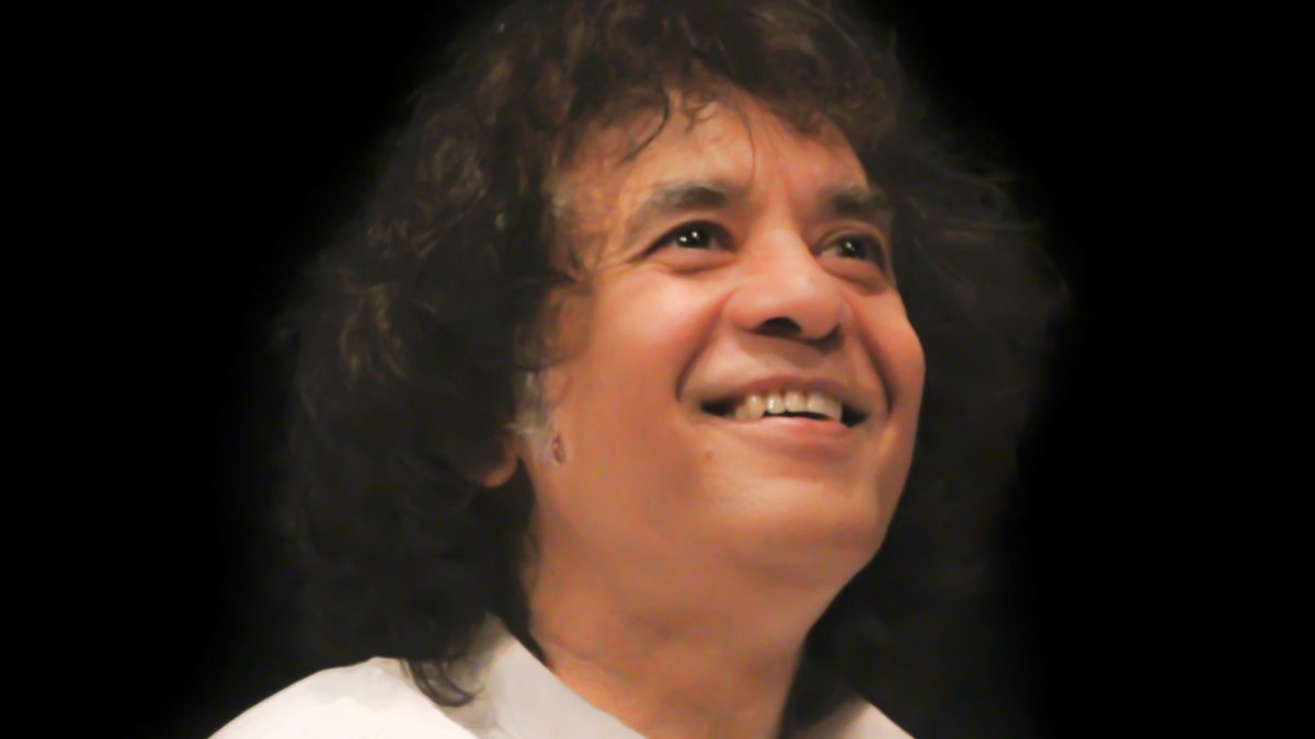 Close-up of Zakir Hussain smiling and looking upward